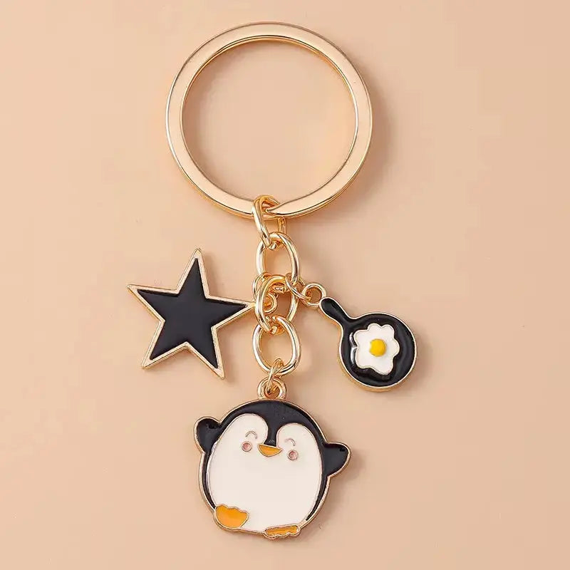 Cartoon animal keychain featuring a cute enamel dog and penguin design, perfect for bags, keys, or as a gift.