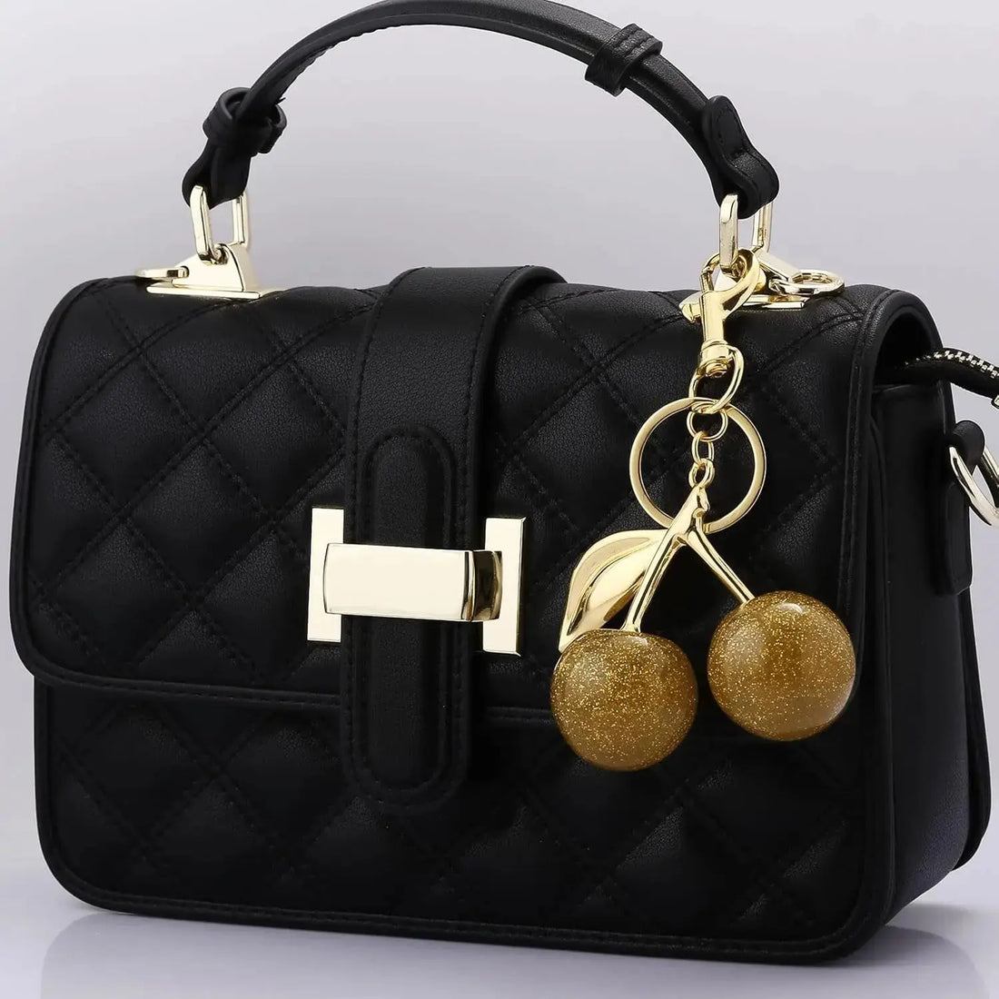Gold cherry bag charm keychain by Hypes Inventory, a cute and stylish purse accessory with fruit design for women.