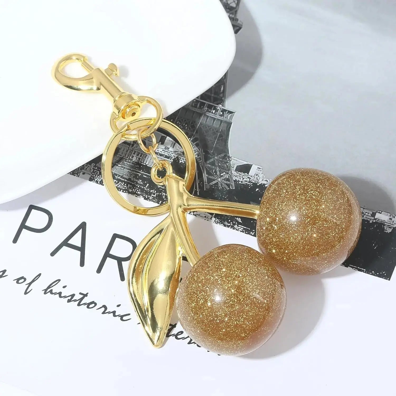 Gold cherry bag charm keychain by Hypes Inventory, cute purse accessory with fruit design for women.