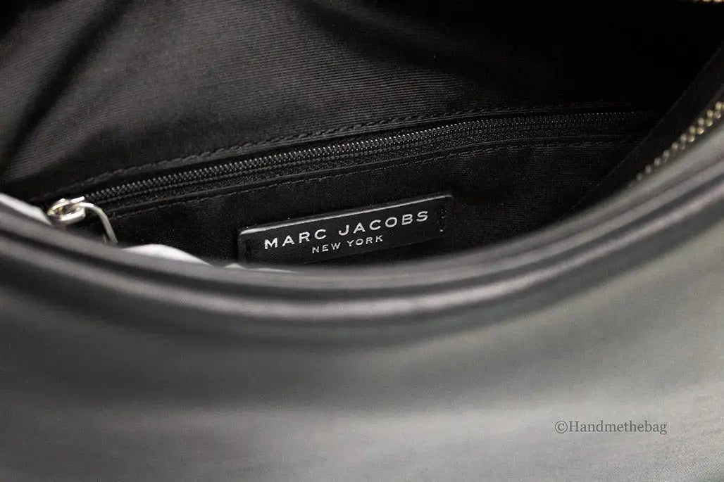 Small black leather hobo bag by Marc Jacobs, designer shoulder bag with soft curved shape and subtle stitching details.