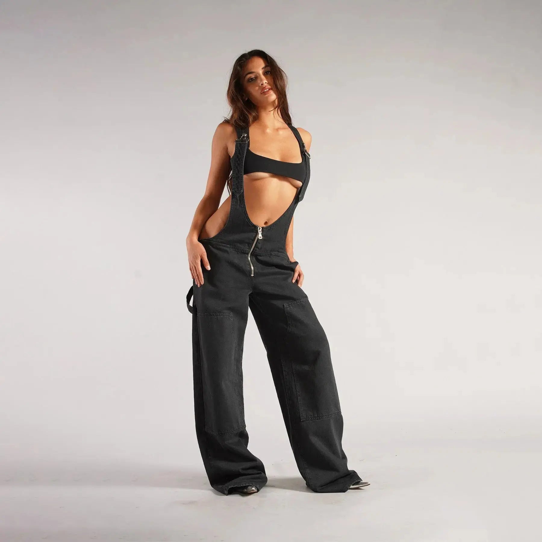 Black Y2K denim overalls for women by Flairé™ with a zip front, loose fit, and front pockets, styled as a casual jumpsuit.