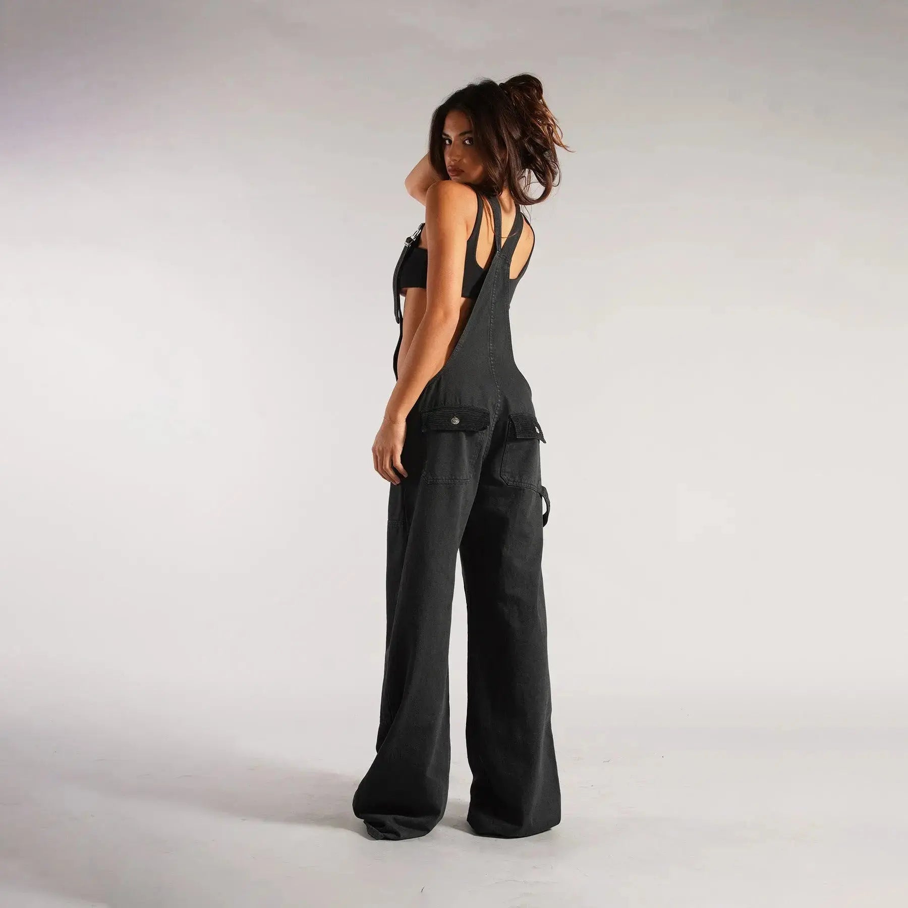 Black Y2K denim overalls for women by Flairé™, loose fit zip front jumpsuit with pockets and casual style.