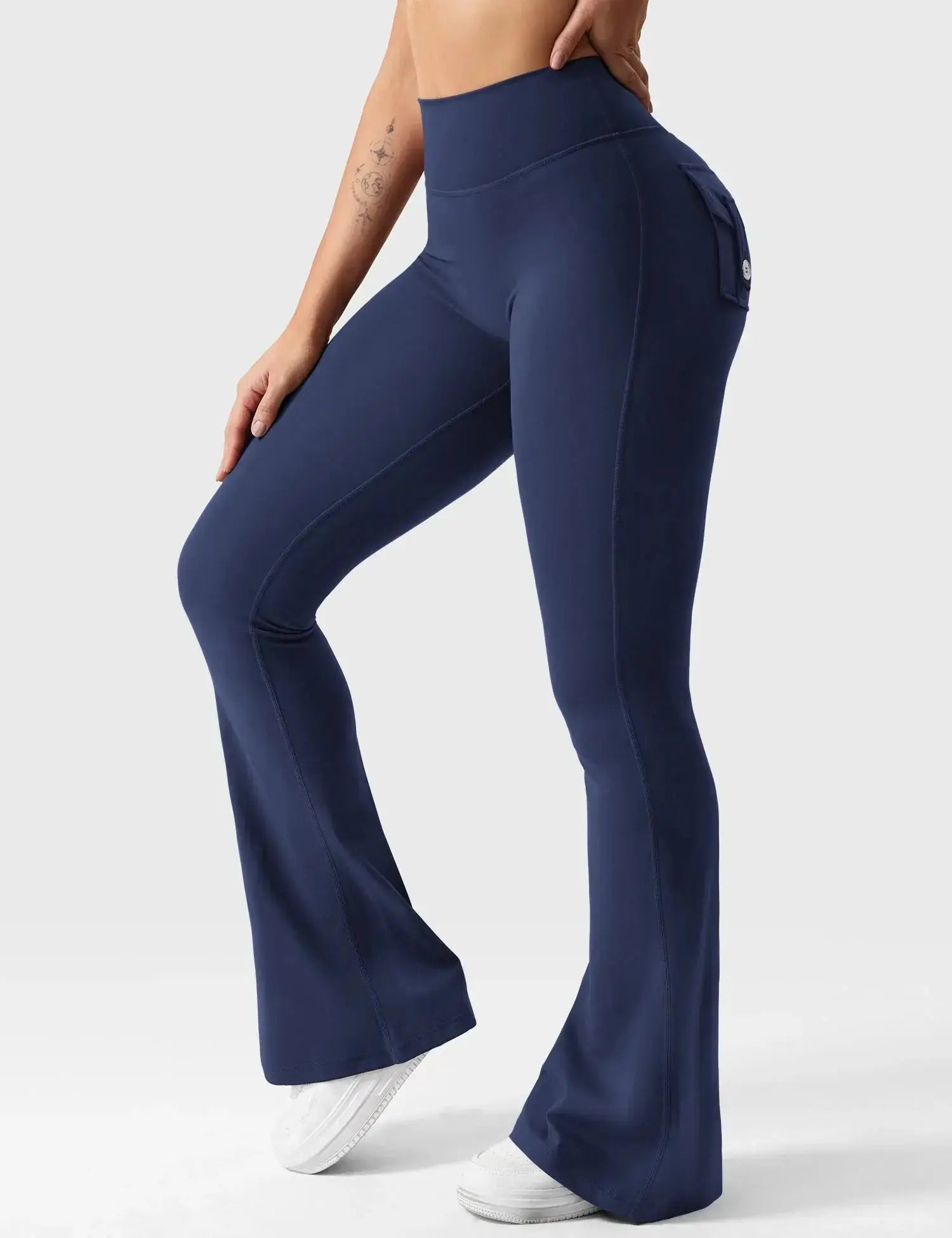 Navy blue Flairé™ 30-inch high-waisted flare leggings with pockets, designed for yoga and athleisure wear, shown on a woman.