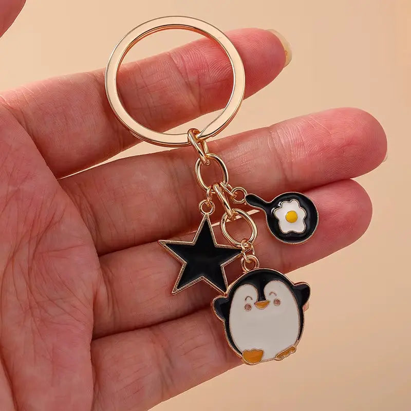 Cute enamel dog and penguin cartoon animal keychain by Hypes Inventory, perfect for bags, keys, and gifts.